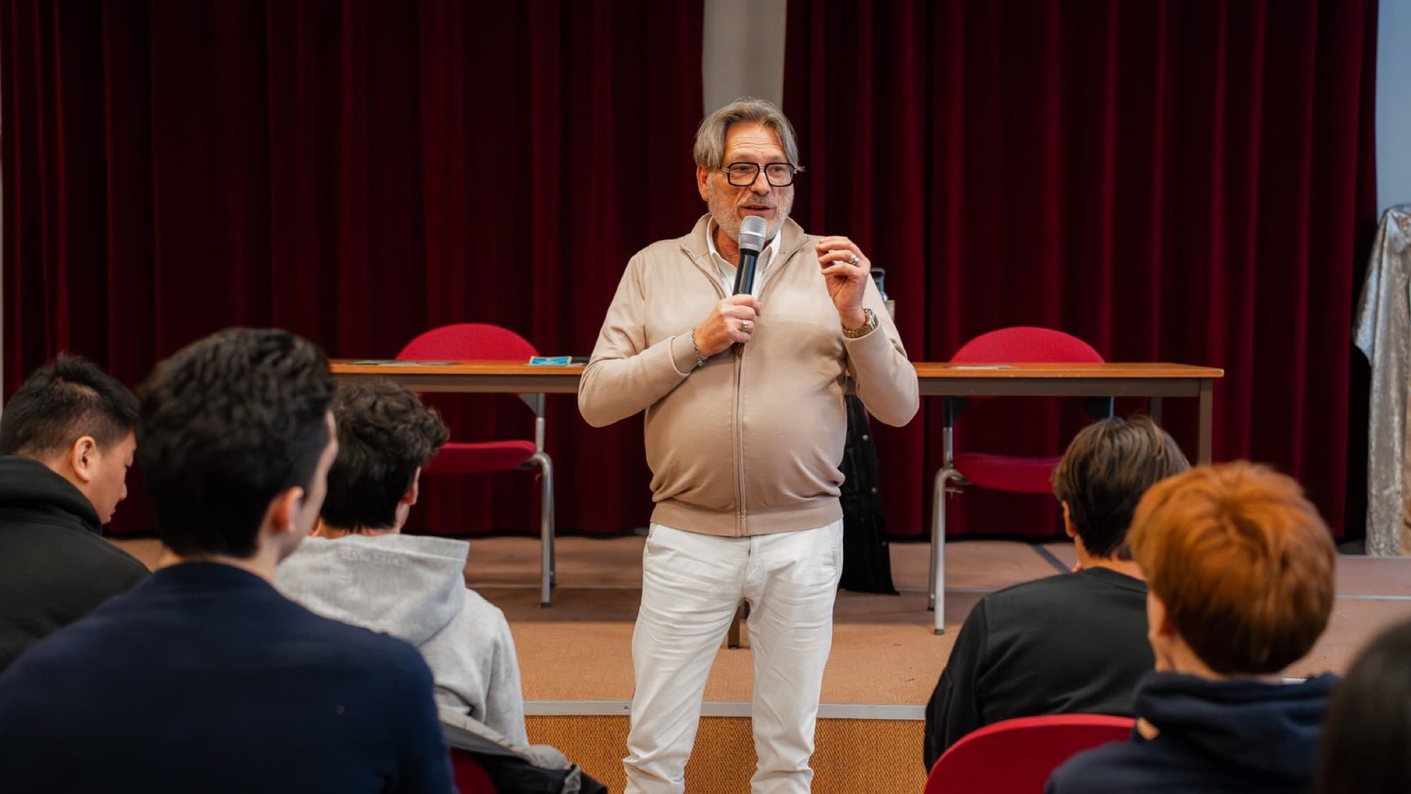 Laurent Gay, fondateur d'AALG, s'adresse au micro à un groupe de lycéens assis face à lui.